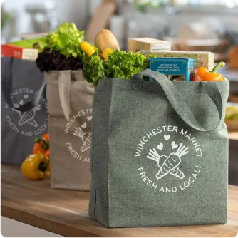 Three re-usable grocery bags in different colors, each with a unique logo graphic.